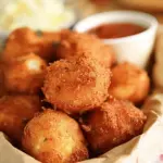 Crispy Sweet Onion Hush Puppies served with dipping sauce, perfect for summer cookouts.