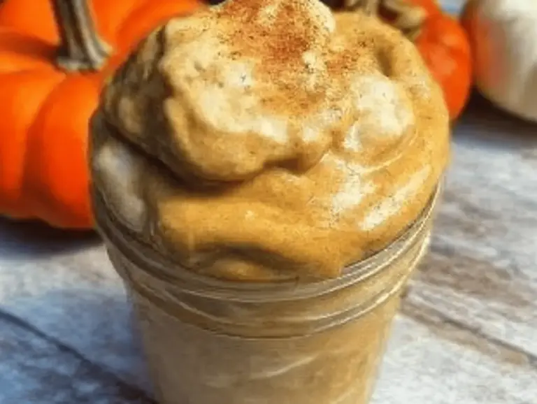 Healthy pumpkin pie smoothie with coconut cream and cinnamon, perfect for fall, served in a clear glass.